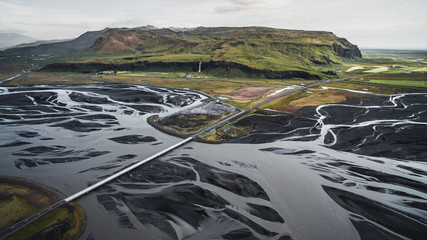 Drone view of Seljalandsfoss waterfall at summer time with a huge delta river riverbed.