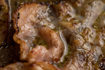 Roasted ham with fat bubbles in the pan, close-up, visible texture of ham and fat, delicious addition to a meal