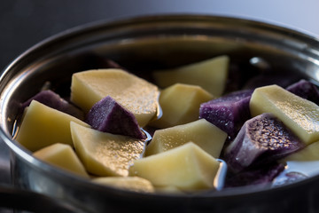 Chopped, washed colorful potatoes in a pot ready for cooking, purple potato, close-up shot, an interesting addition to dinner