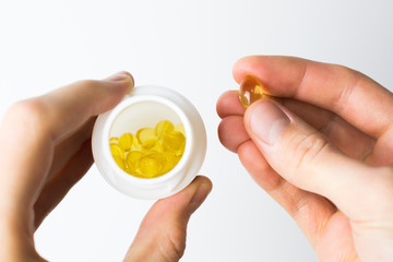 Omega 3 capsules, healthy eating, diet, food supplement. Hand holding fish oil capsule.