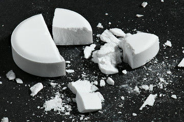 One broken white pill on black background macro photo - concept of medicine and medication...