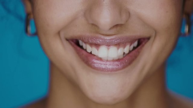 close-up of perfect woman lips smiling on blue background