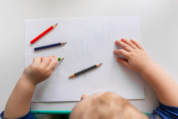 Left handed baby boy drawing a picture