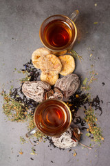 cups of tea and dried fruits on a gray background top view