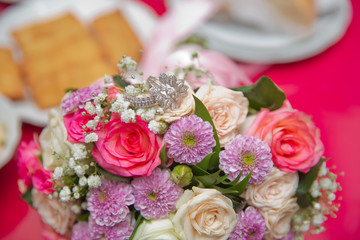 close up wedding ring on top of a colorfull bouquet. . macro .Close up of wedding rings on the bouquet . Macro . Bride and groom with Engagement gold rings put on the clorfull wedding bouquet .