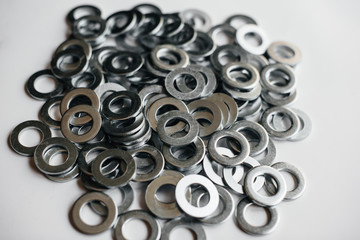 Pile of washers, bolts and nuts on a light background close-up