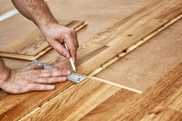 A craftsman lays oak parquet with a click system