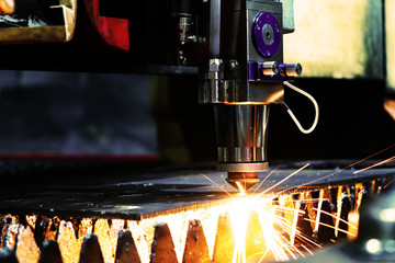 Bright flash from an industrial laser that cuts a sheet of metal. Industrial laser at work in...