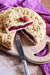 Homemade berry shortcrust pie with crumble on wooden board
