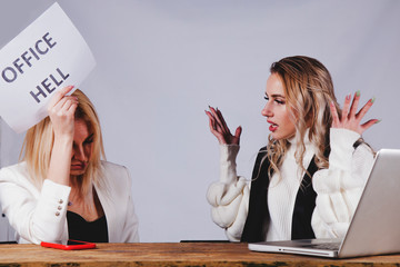 Unstable female boss aggressive gesturing and screaming at her employee. Young employee holding...