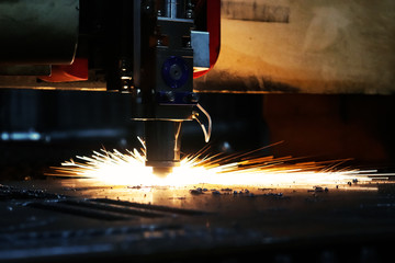 Bright flash from an industrial laser that cuts a sheet of metal. Industrial laser at work in production.
