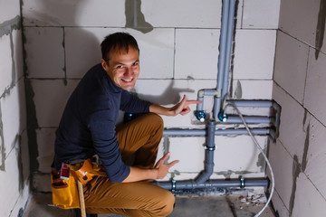 plumber makes wiring of sewer pipes