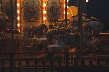 Carousel with horses in amusement park at night