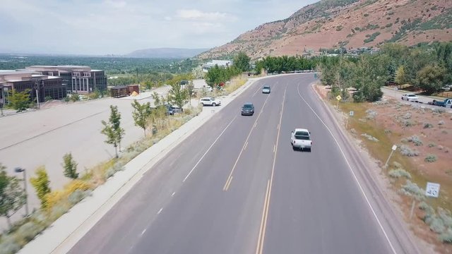 Aerial view: Black car rides on an empty city road in USA