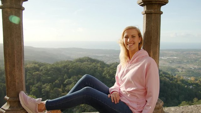 Young woman sits on the wall of Palace of Pena in Portugal - travel photography