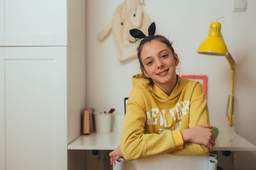 young girl, preteen, sitting desk in her room