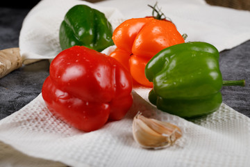 Color peppers and garlics on a white tissue.