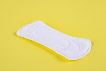 One sanitary pad on a yellow background.