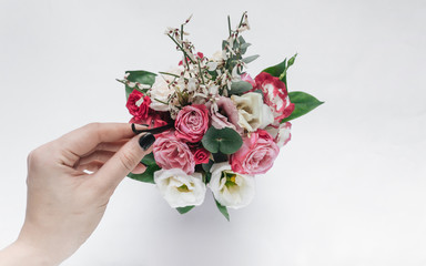 Female hand touching beautiful spring bouquet with tender flowers