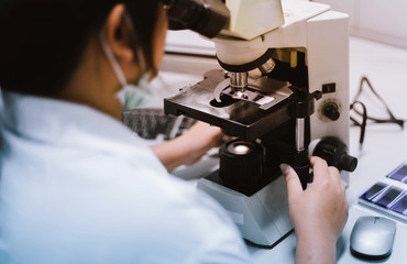 Scientist use microscope with glass slide in medical laboratory