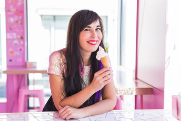 Summer, youth and dessert concept - Pretty girl enjoying an ice-cream cone in cafe