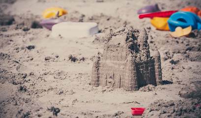 Sandcastle on the beach. Beach toys on vacation. A way of spending free time by children on vacation.