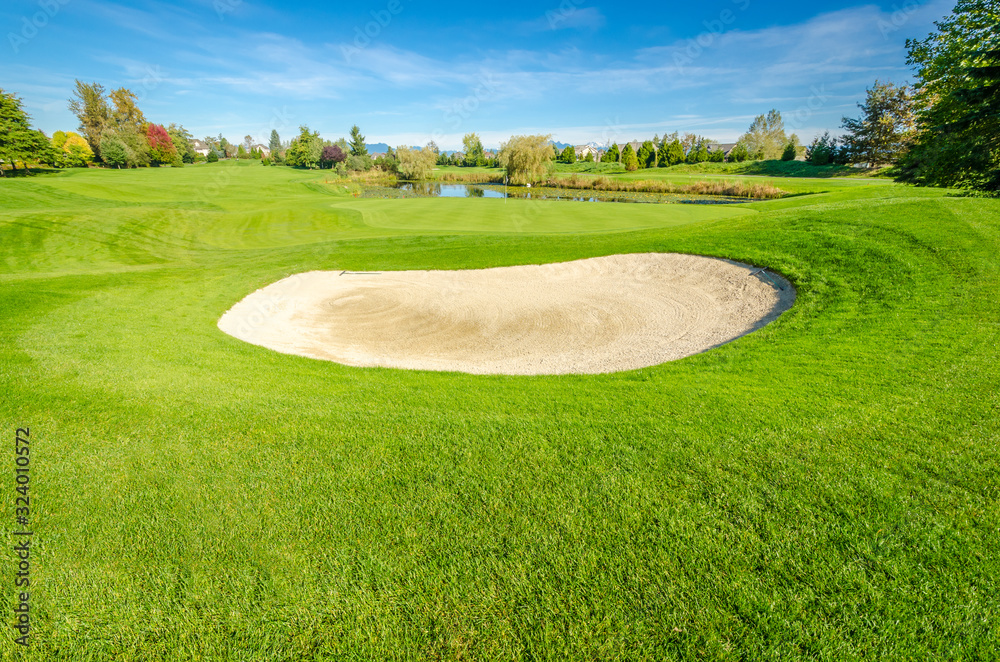 Wall mural golf course with gorgeous green and sand bunker