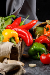 Fresh colorful chili peppers on a blue table.
