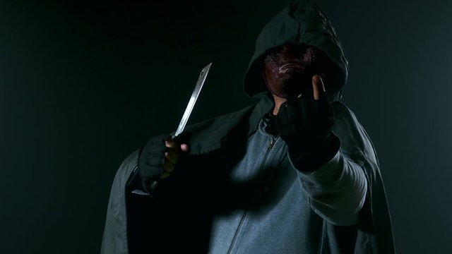 Scary killer in mask and hoodie