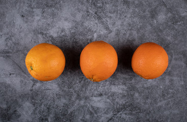Three oranges in a row. Top view.