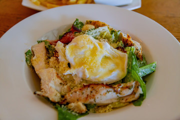 Close up shot of a plate of traditional egg and fried chicken breast