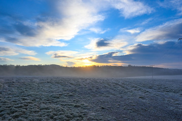 Sunrise and fog over landscape in hoarfrost 