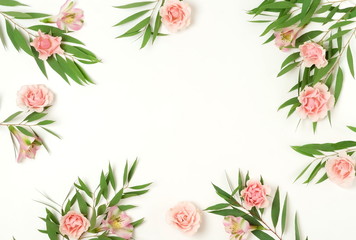 green eucalyptus leaves, branches and pink flowers frame, border isolated on a white background. Copy space, flat lay, top view. floral card