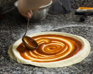 Fresh original Italian raw pizza preparation, close-up of man hands in action,Pizza Art. The process of making pizza