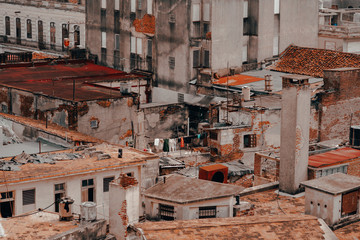 From above of colorful buildings and skyscraper with blue sky on background on streets of Cuba