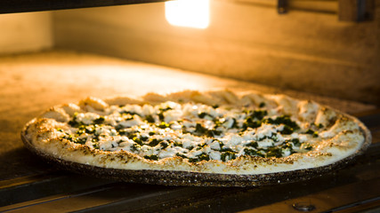 Delicious Pizza with a lot of ingredients baked in the oven,Italian Pizza,Putting pizza in oven at restaurant kitchen