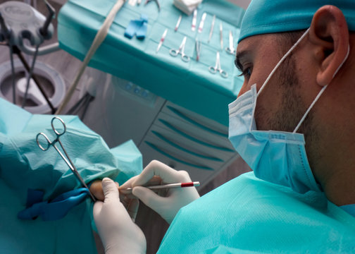 Professional male surgeon starting operation on thumb of feet in hospital