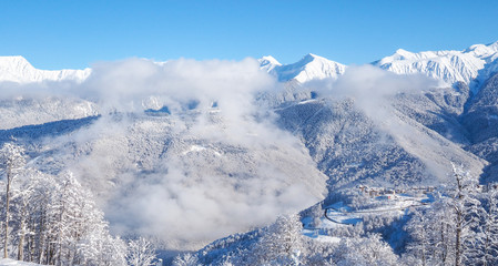 Fototapeta na wymiar Beautiful winter mountain landscape with view of the top of mountains. Panorama above the clouds, winter fairy tale