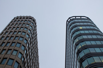 Fragment of the facade of a modern glass skyscraper with reflections and a lantern on the background of a cloudy sky with copy space