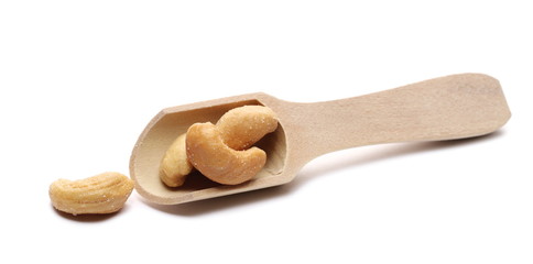Salted cashew nuts in wooden spoon isolated on white background