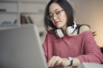 young asian woman works with laptop