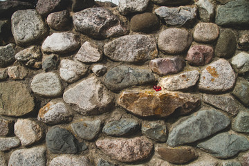 A red heart on a stone wall. Copy space. Glass keychain in the form of a heart.