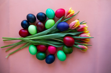 Bouquet of tulips with colored eggs as a postcard for the Easter holiday