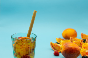 Drinking glass with blood orange and red fruits with oranges on the right. Healthy food concept.