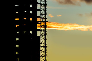 Naklejka premium Construction site with cranes at sunset, sunrise, dawn time with the cranes as a silhouette. Vancouver, Canada.