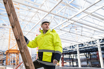 A man worker outdoors on construction site, working.