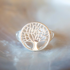 Sterling silver ring with tree in mandala shape on white shell background