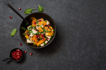 Rustic salad with pumpkin, chicken , spinach and pomegranate seeds
