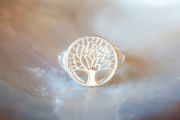Sterling silver ring with tree in mandala shape on white shell background