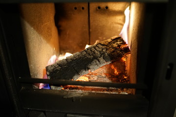 Glowing burning wood log at fire place 